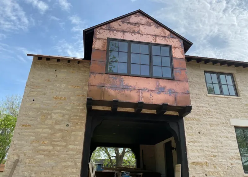 Copper metal panel facade on a stone building for Skylight Installation in Aurora